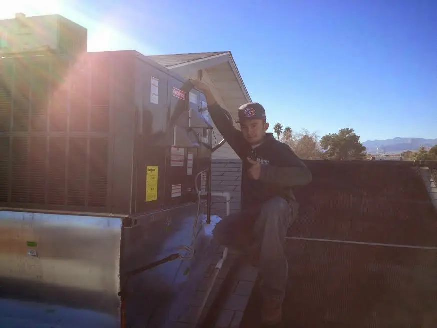 HVAC technician performing AC Tune-Up on a rooftop unit in Towson